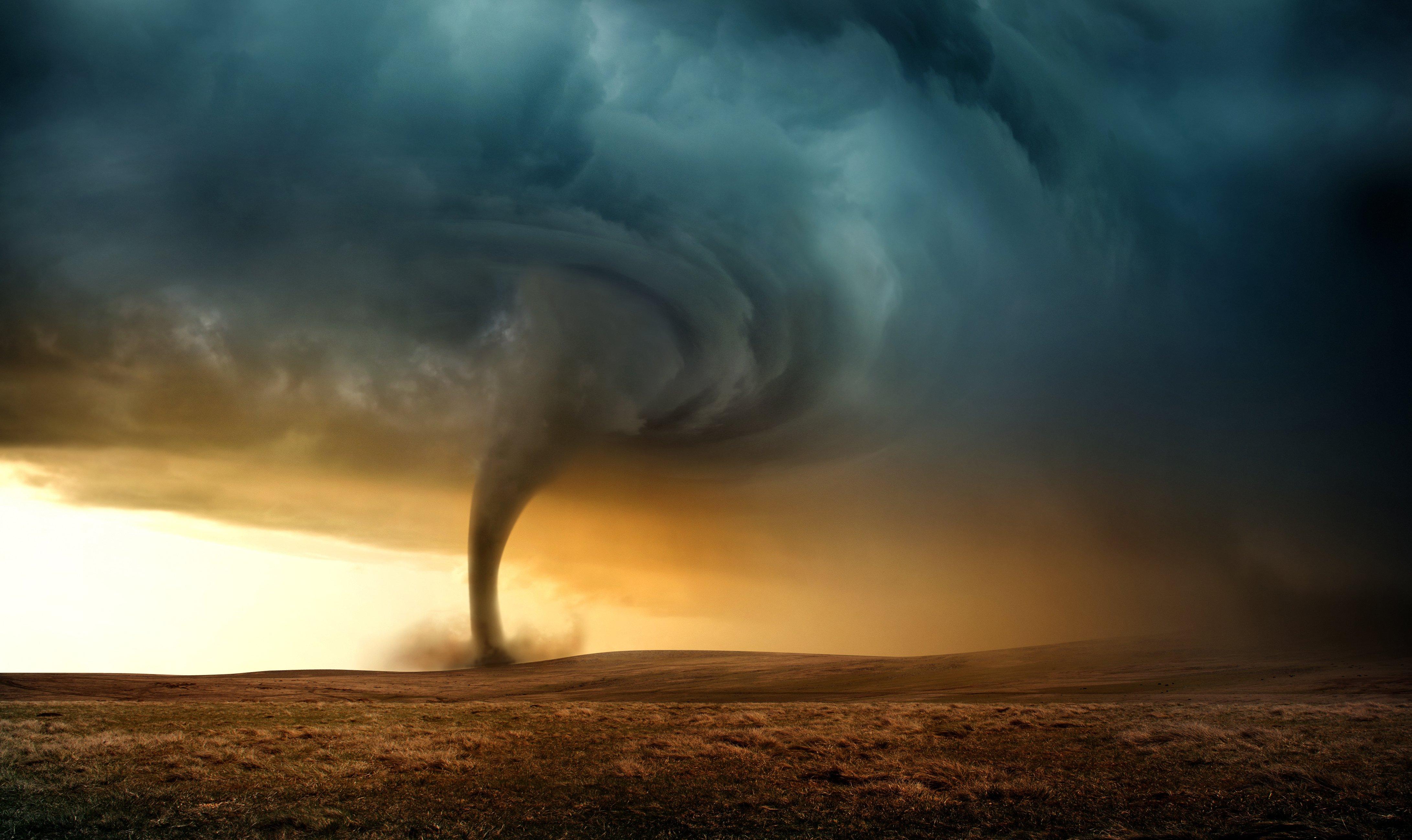 A large tornado touches down on a plain.