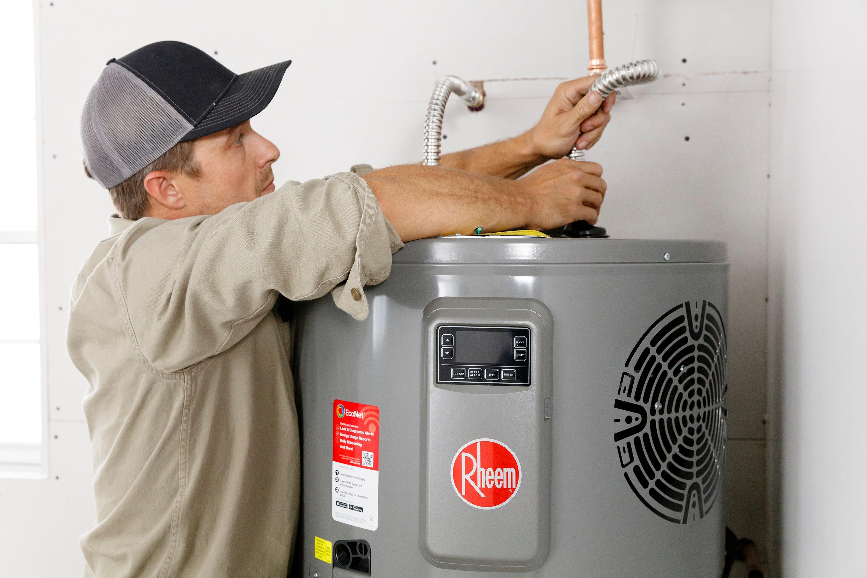 Man installing a Rheem gas water heater.