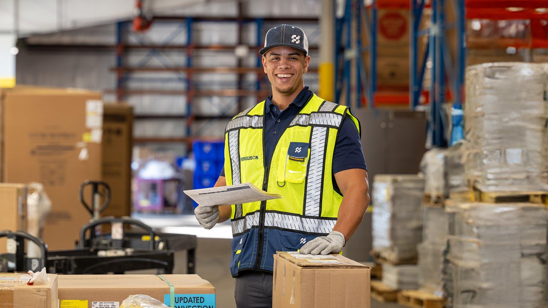 Man standing with boxes on a moving dolly.