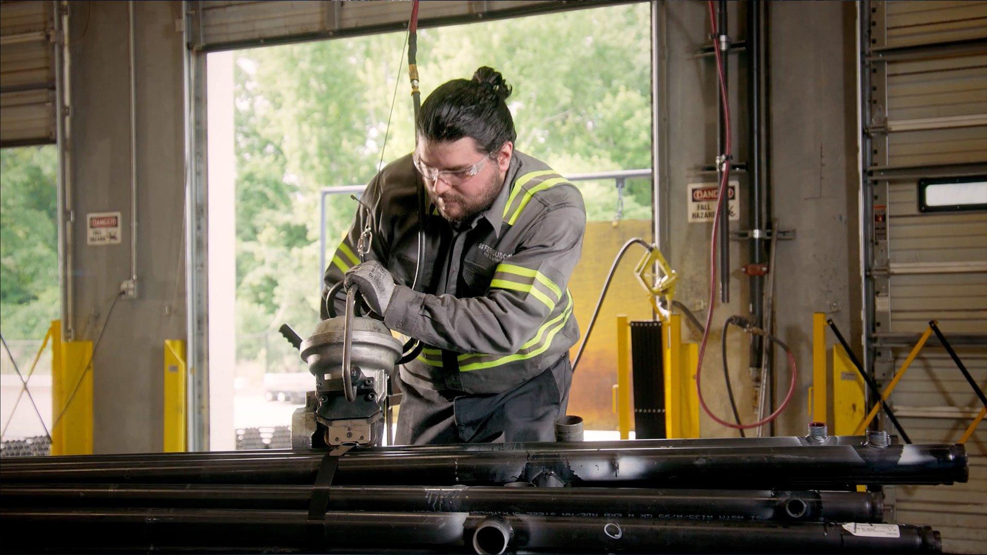 Ferguson associate bundling fire protection pipe together in a warehouse