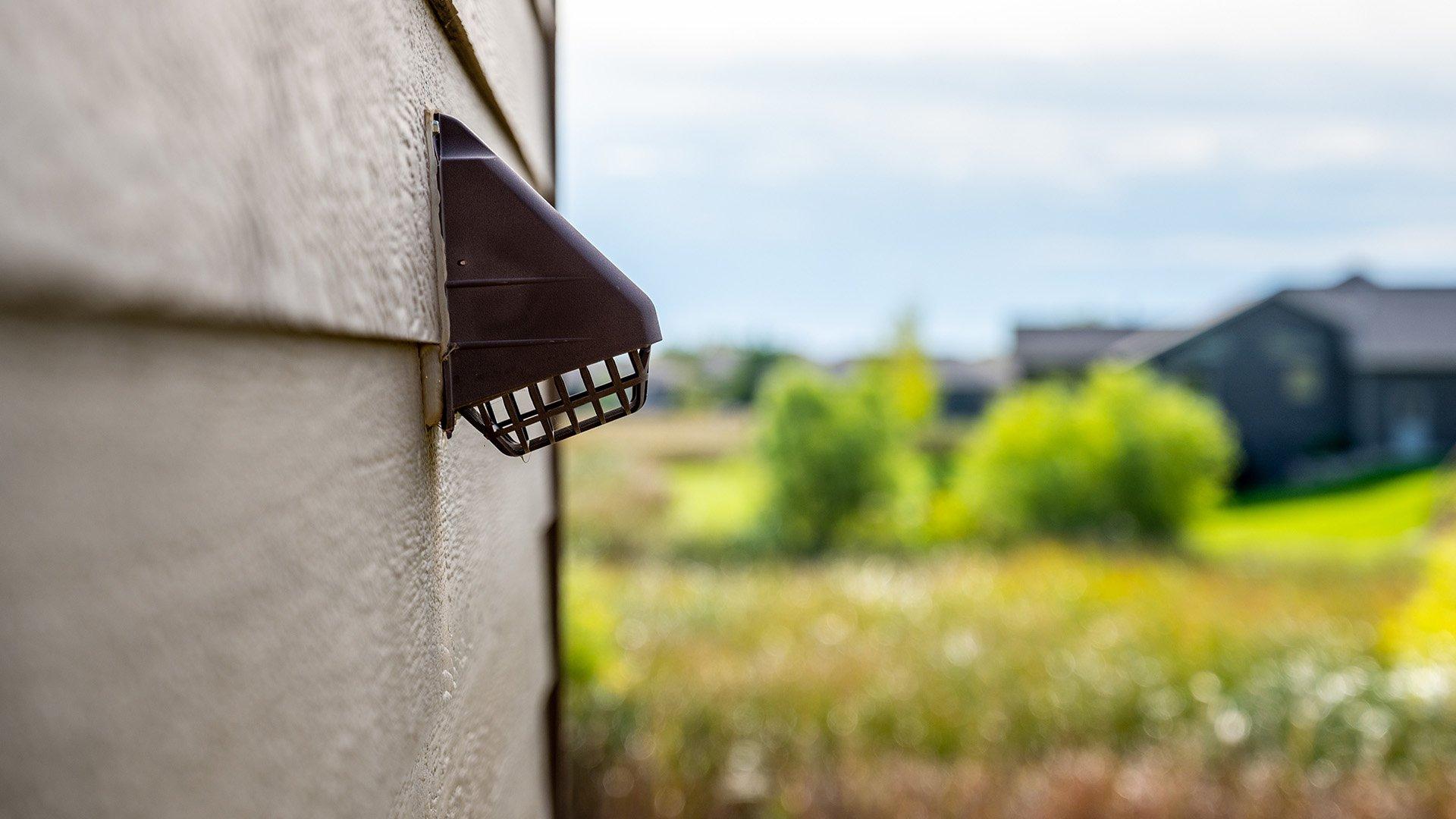 Silo image of dryer vent on the side of residential home. 