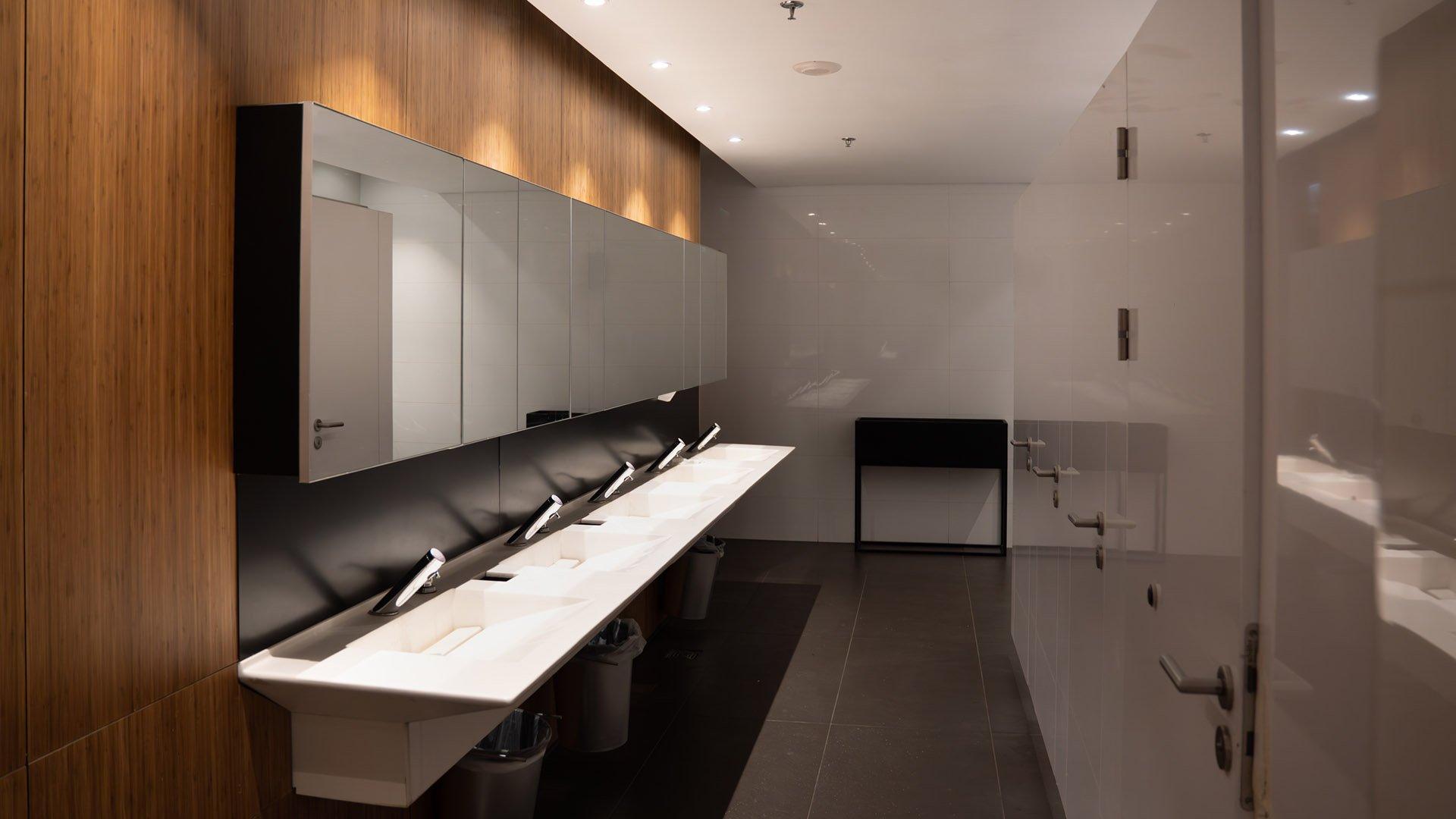 Public restroom with ADA compliant sink, grab bar, and toilet.