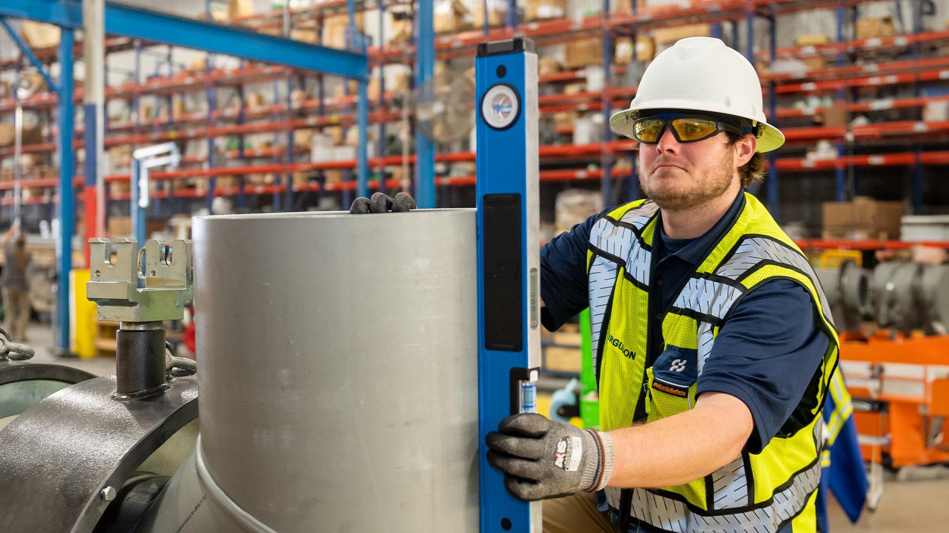 A Ferguson associate inspects fusion machine equipment in a warehouse.