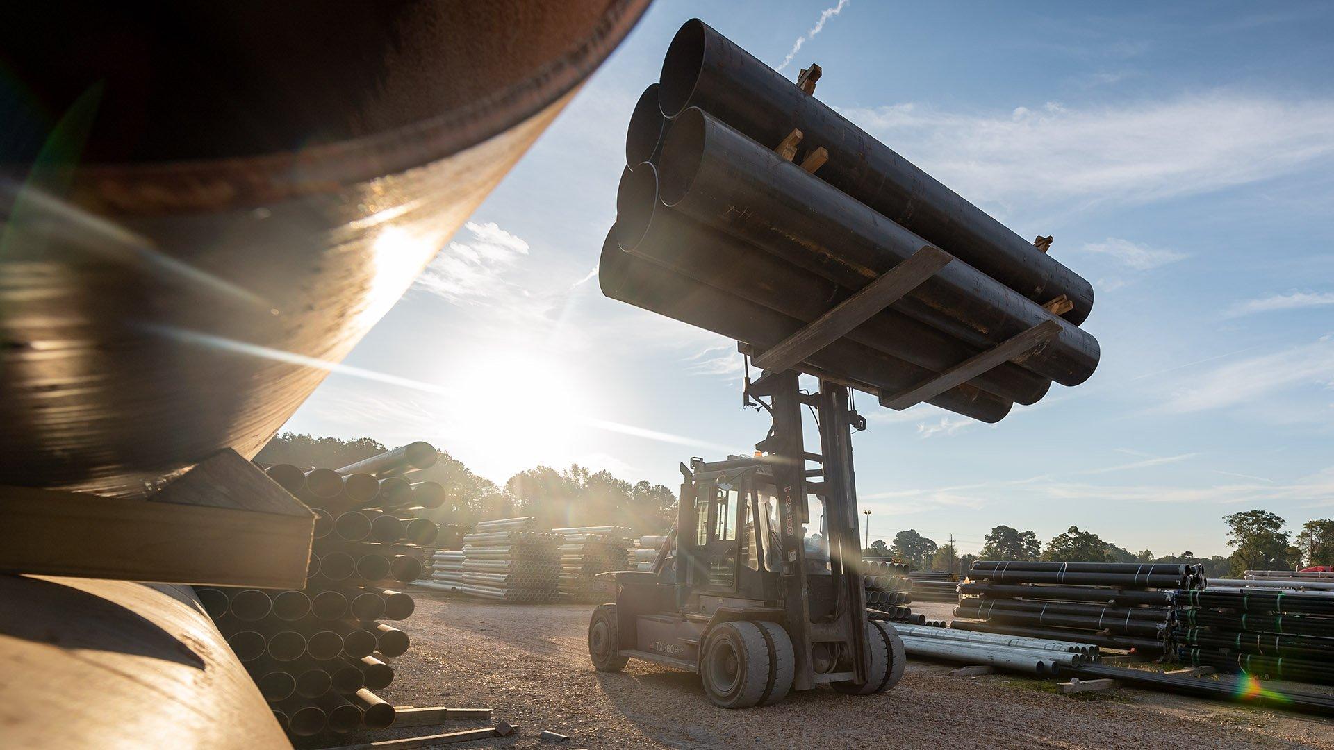 A forklift truck moves industrial pipe at a Ferguson fabrication center.