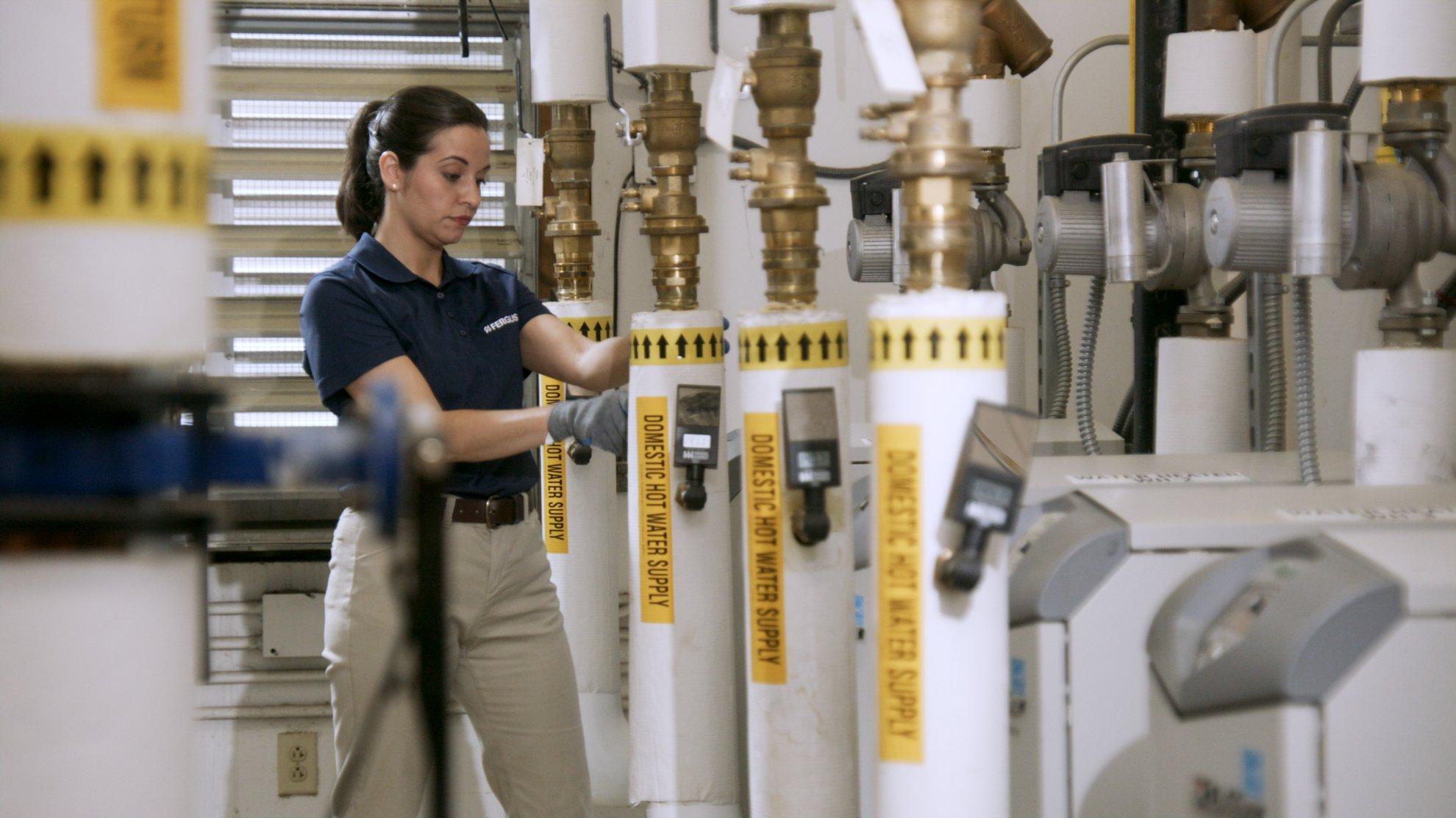 A Ferguson associate tests water pressure in a row of hot water supply systems.