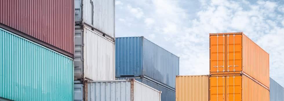Different-colored shipping containers are stacked.