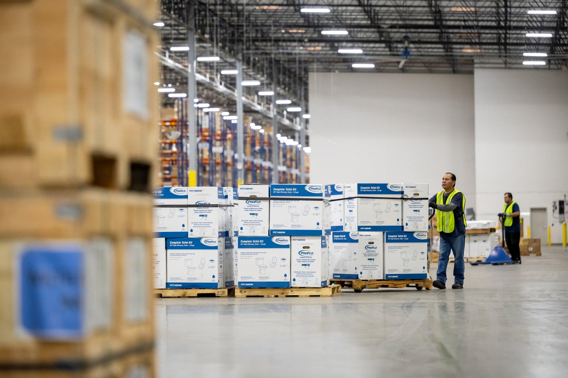 A Ferguson associate pushes a pallet of products in a warehouse.