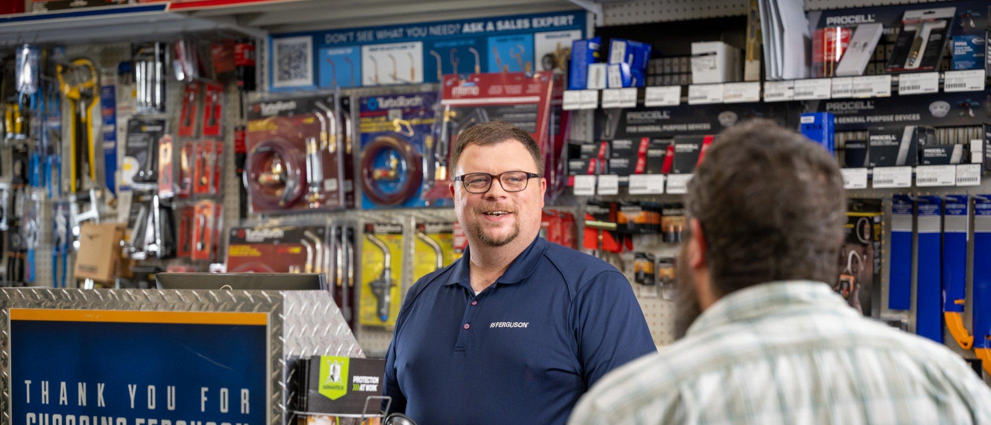 A Ferguson associate talks with a customer at a counter location.