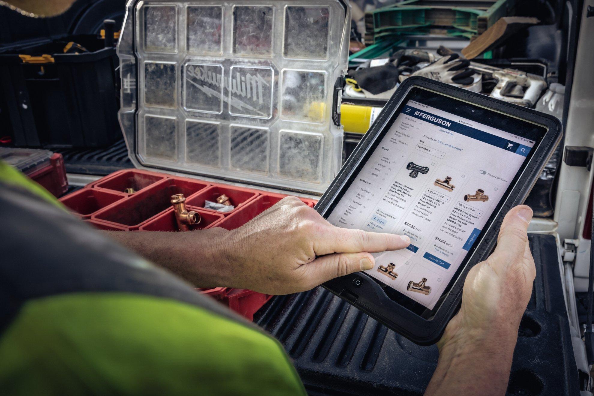 A contractor scrolls through Ferguson products on a tablet.