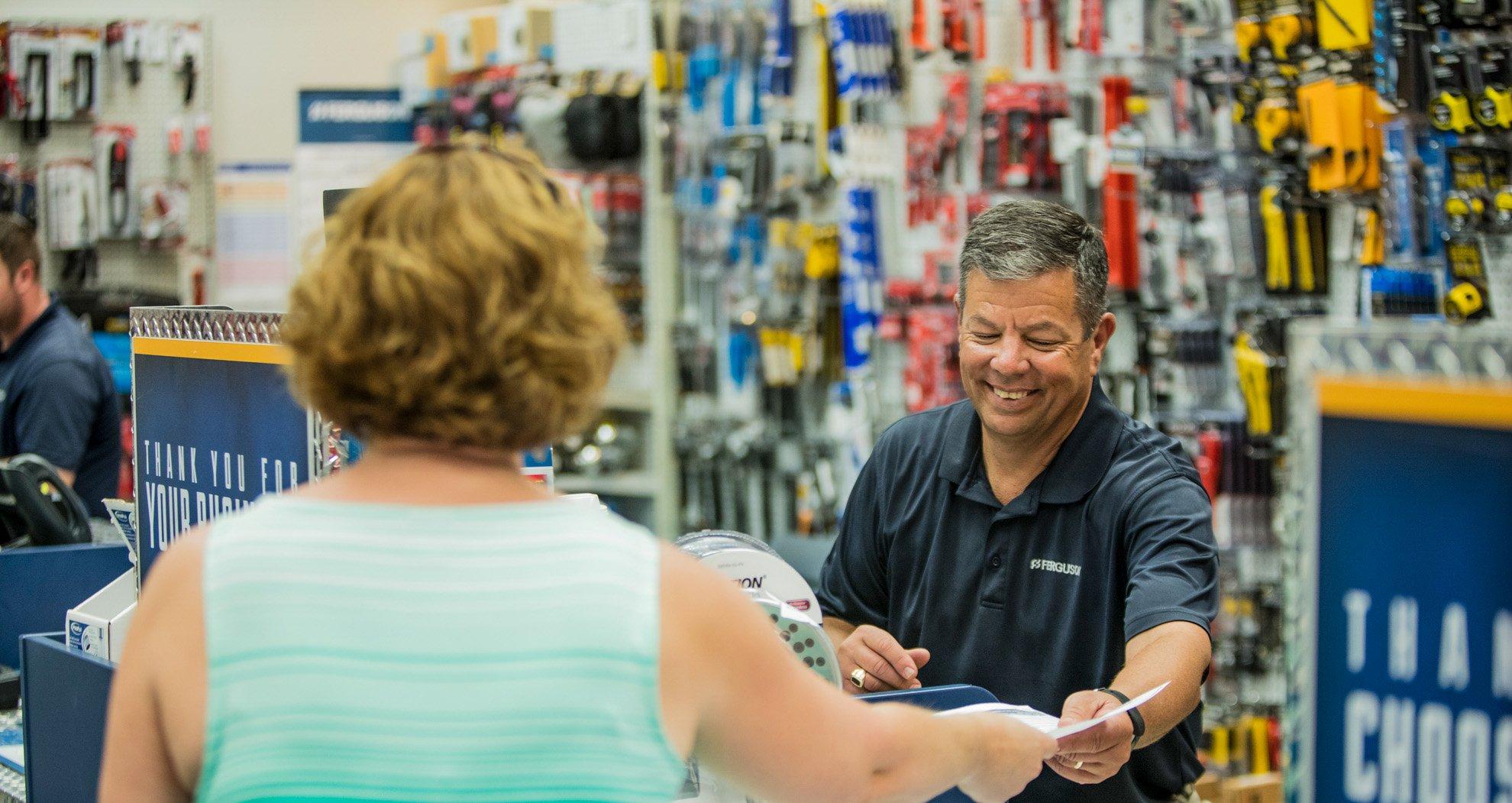 A Ferguson associate helps a customer at a counter location.