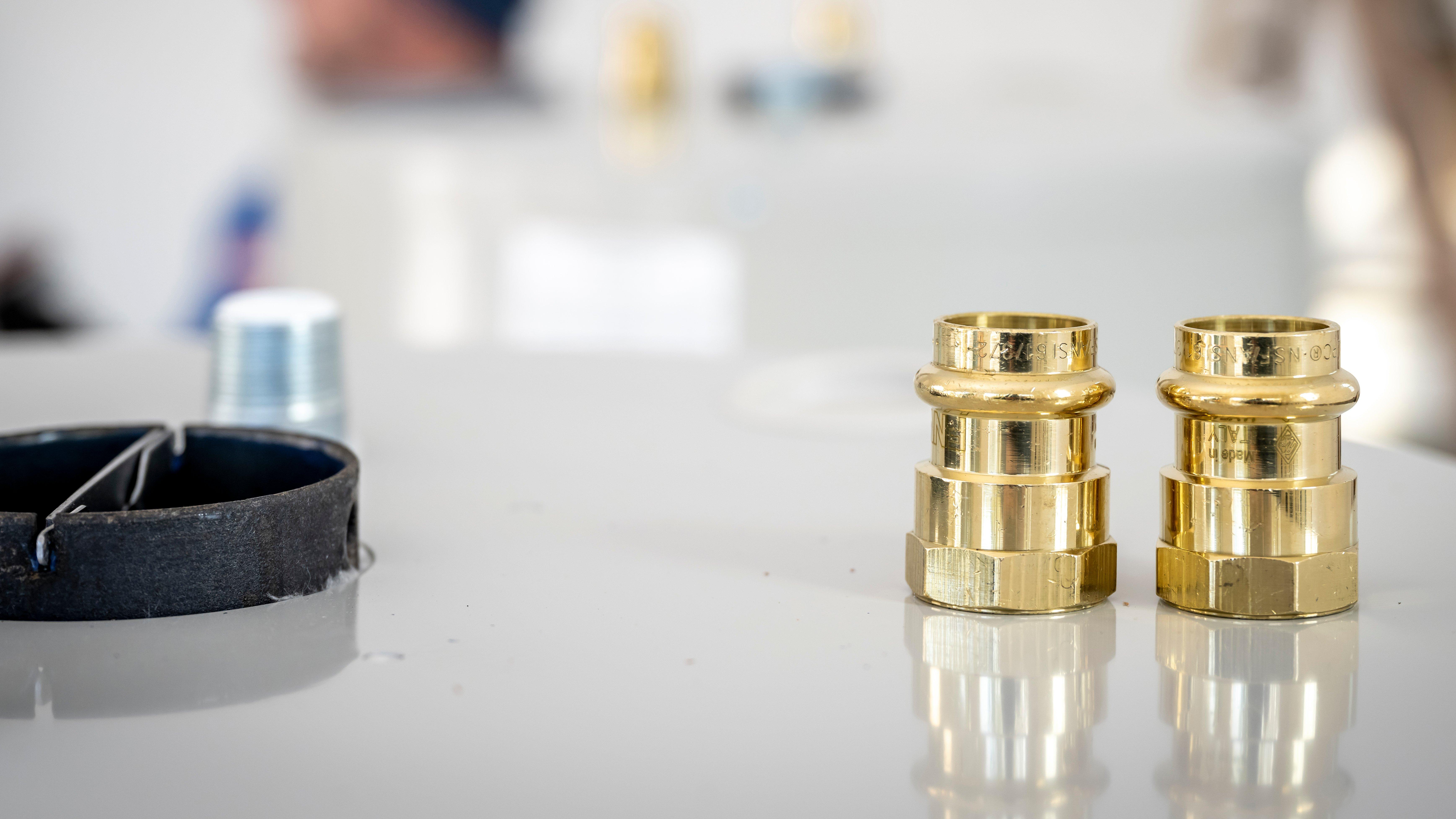 Brass water heater valves sit on top of a water heater.