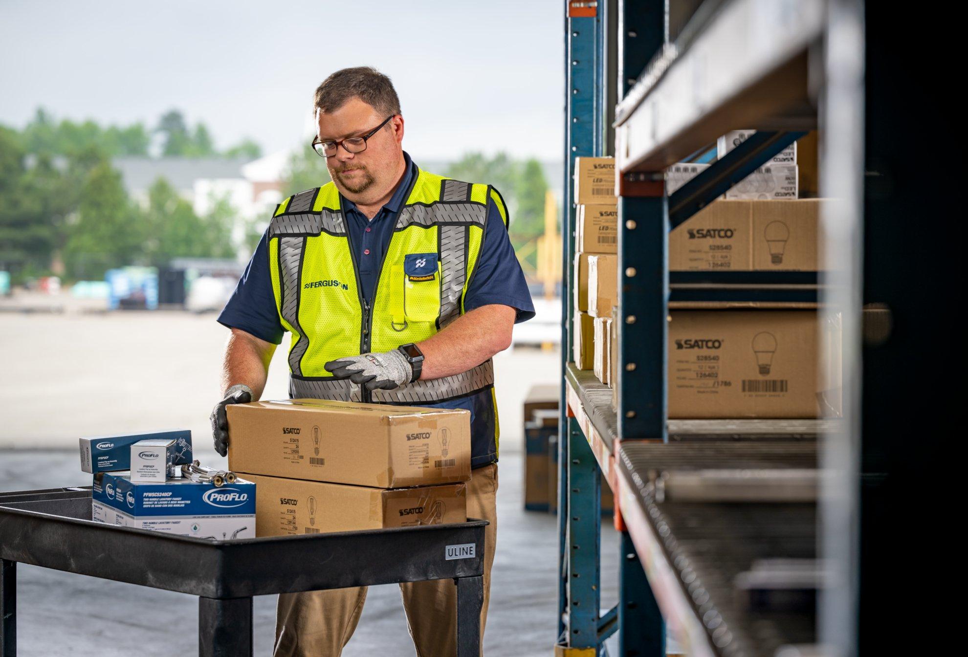 A Ferguson associate in a distribution center loads deliveries of products onto warehouse shelves.