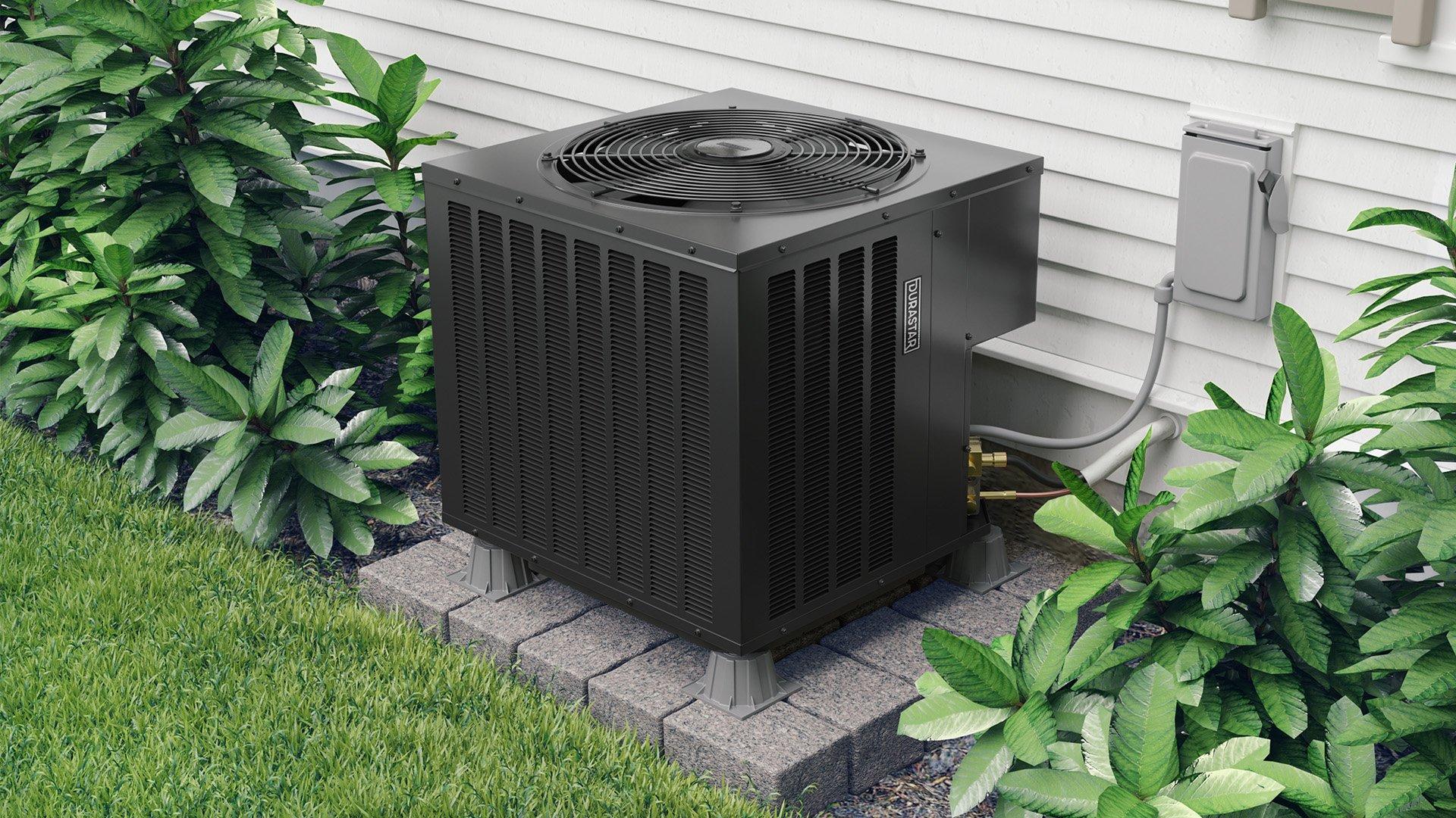 Lifestyle photo of black, Durastar residential heat pump installed outside home.