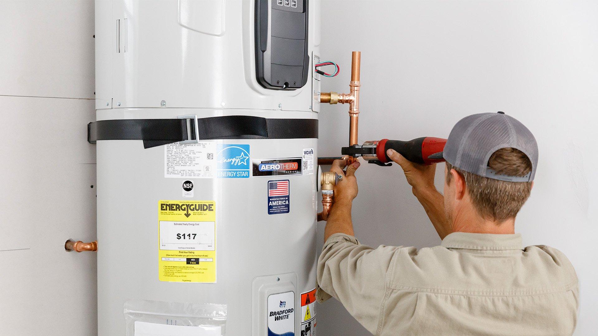 Plumber installs a hybrid heat pump water heater in residential home. 