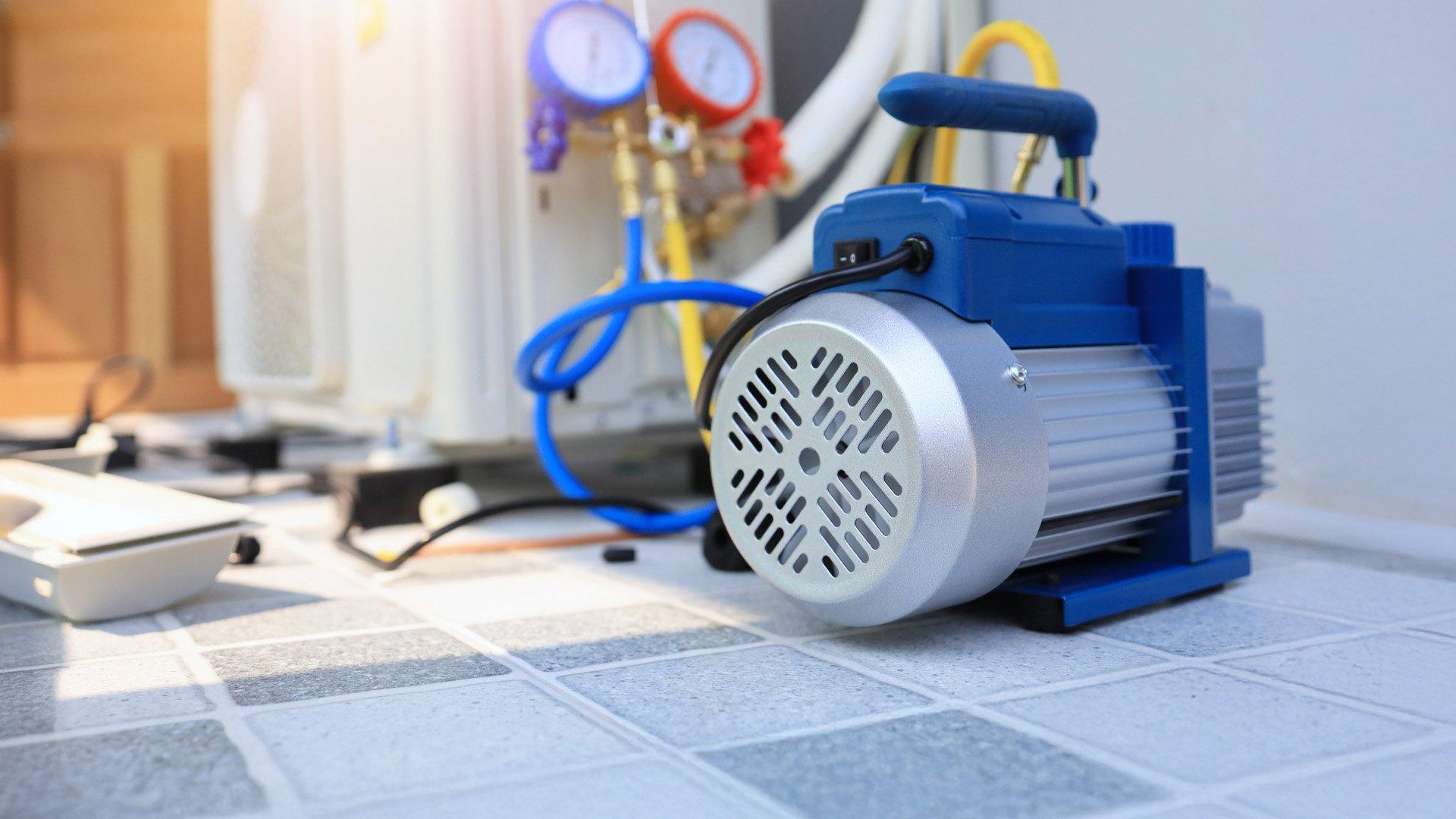 Vacuum pump unit is placed beside the outdoor air conditioner unit and manifold gauge.