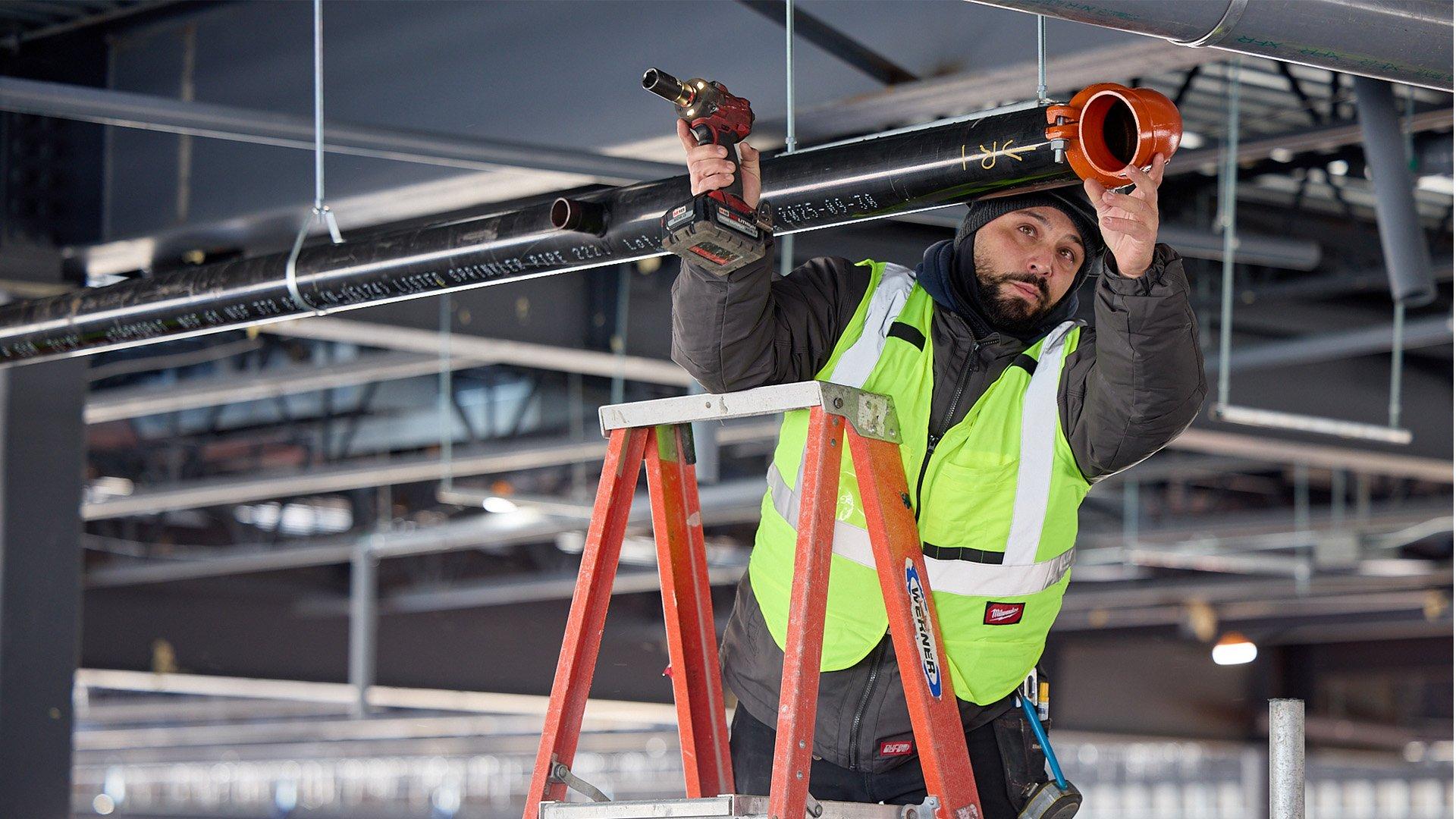Contractor installs fire sprinkler pipe in commercial building. 