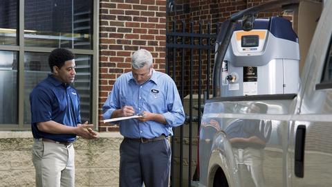 A contractor signs for delivery of a commercial water heater.