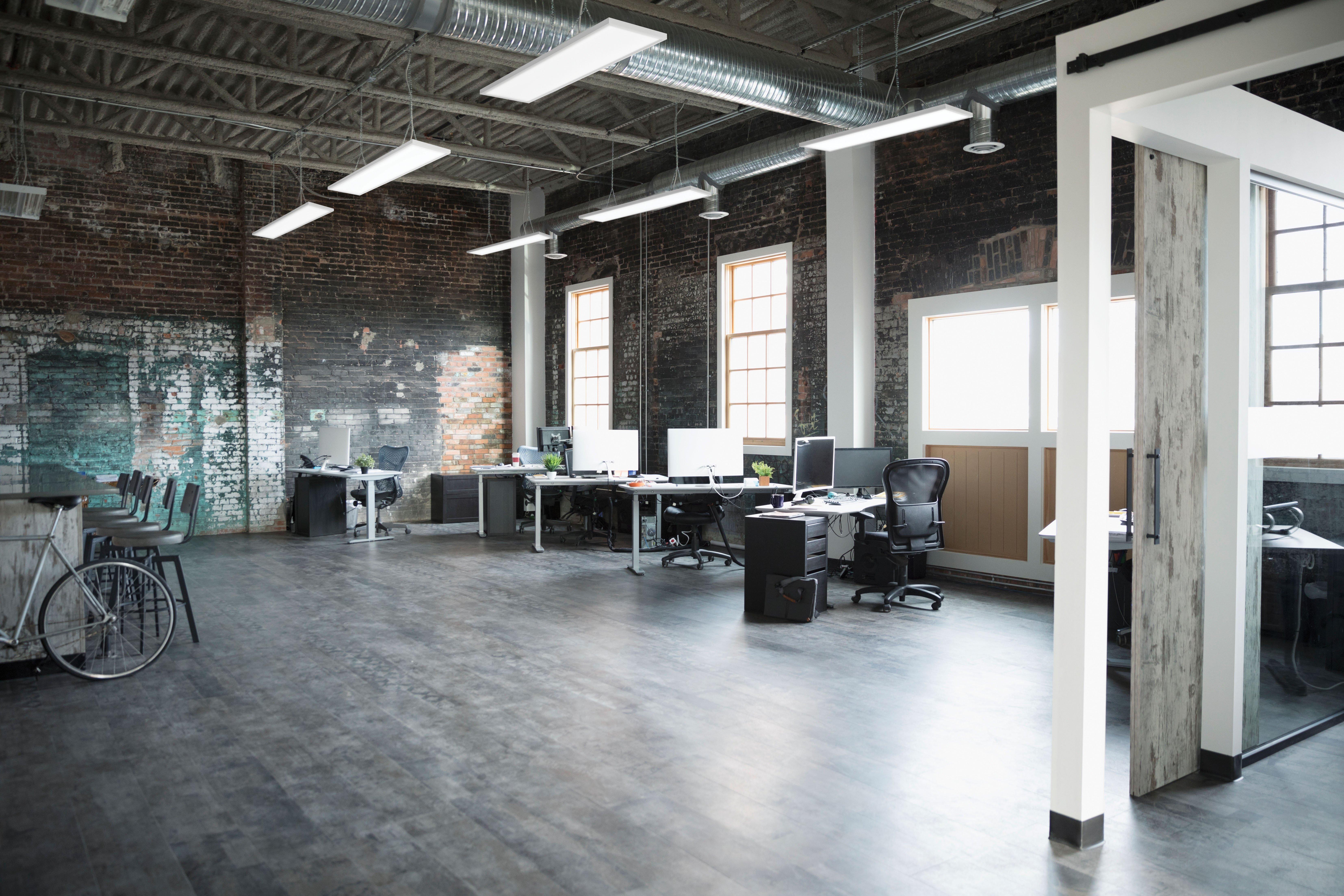 A modern office space for a creative business with overhead LED lighting.