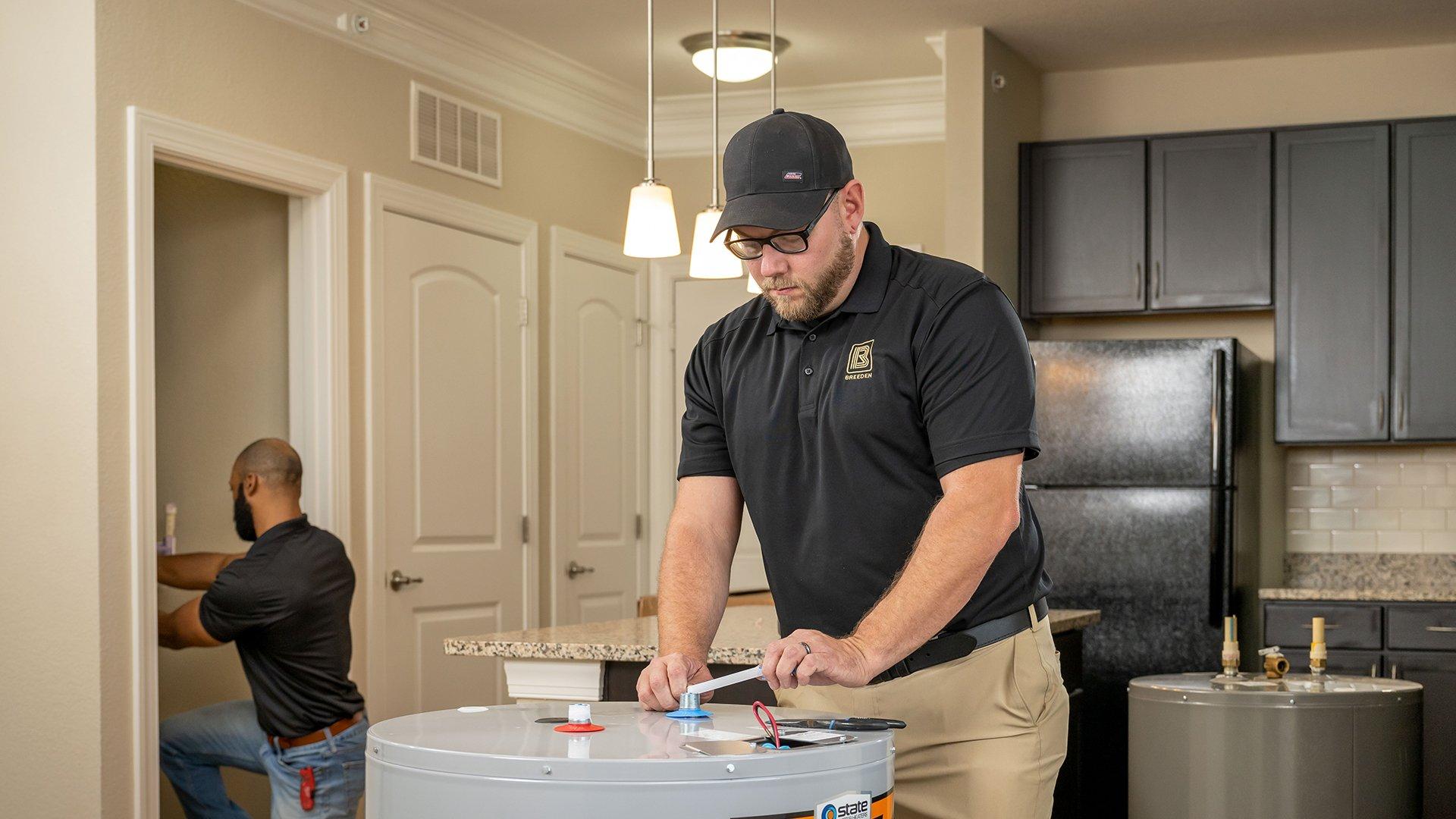 Man adjusting a water heater in new apartment.