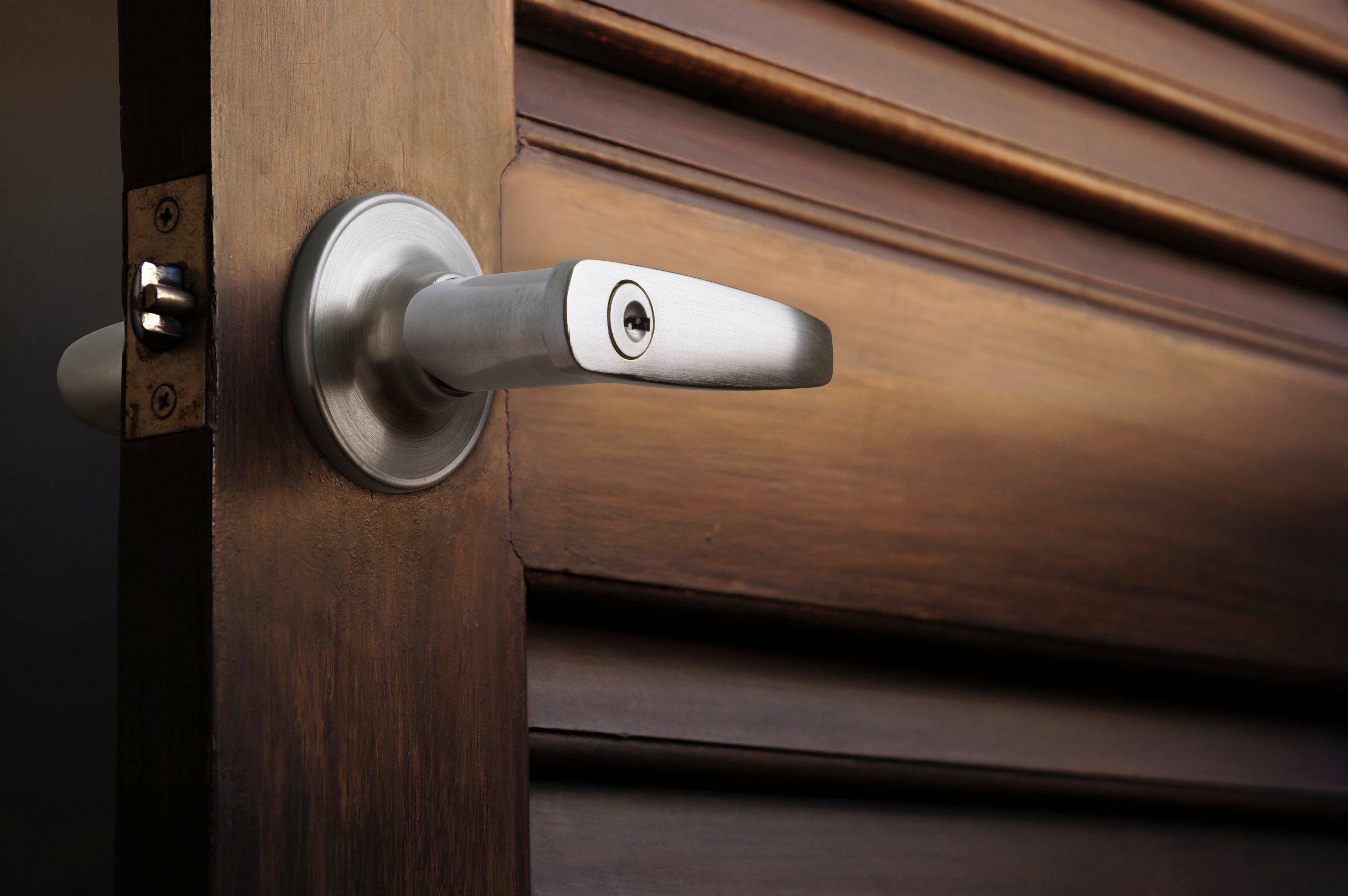 Closeup of a locking door handle on a wooden door.