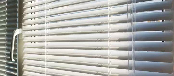 Closeup view of custom cut window blinds hung on a window.