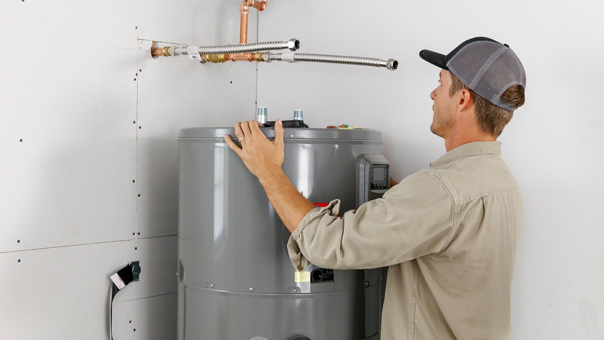 Technician installs residential water heater in home. 