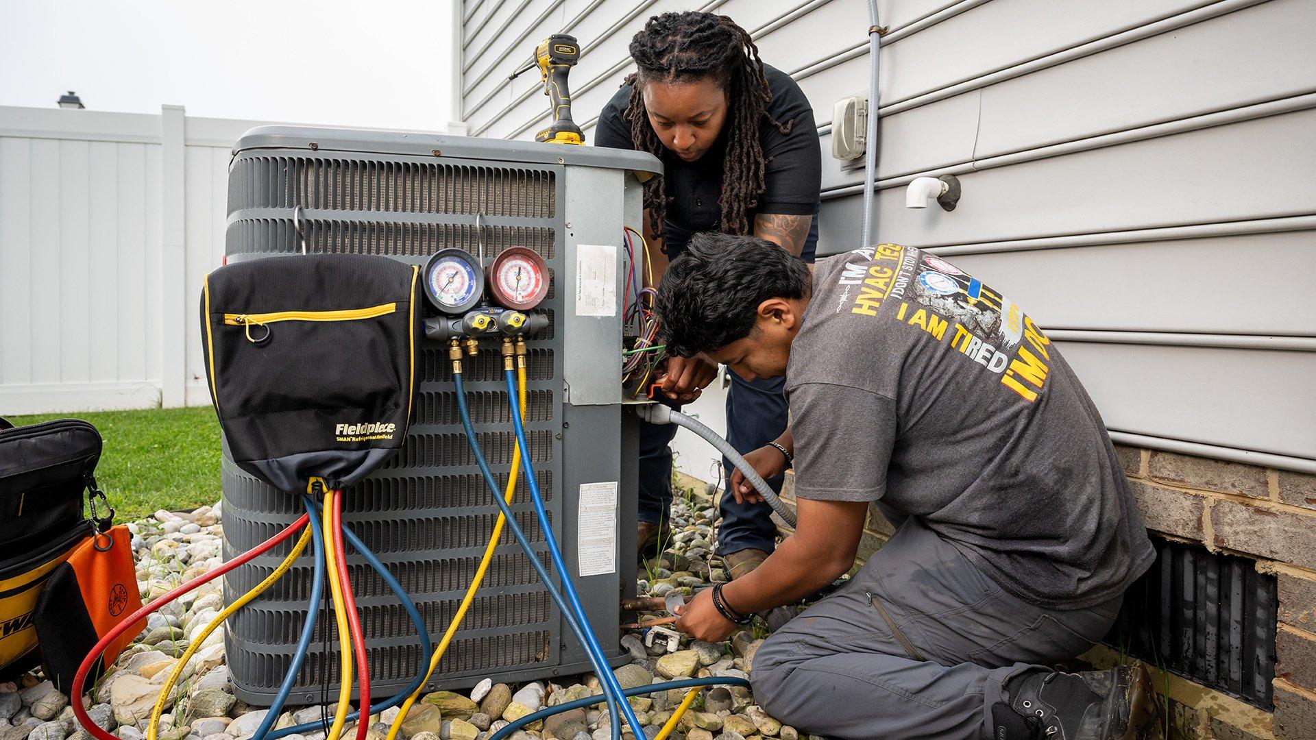 HVAC technicians repairing a outdoor condensing unit
