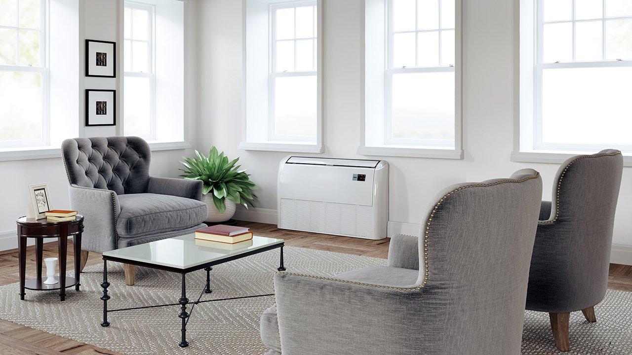 In a well-appointed living room, a mini-split HVAC unit is installed under a row of windows.