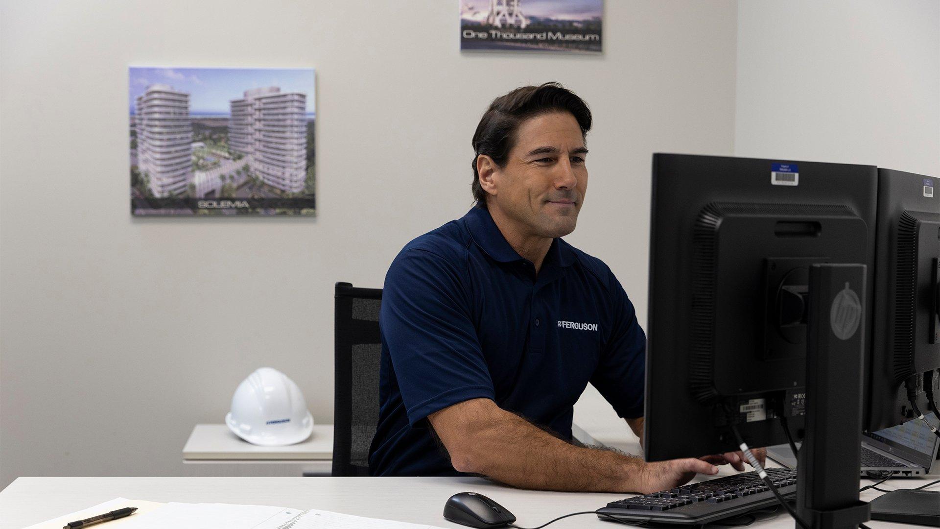 A Ferguson associate types at a computer while sitting at his desk.