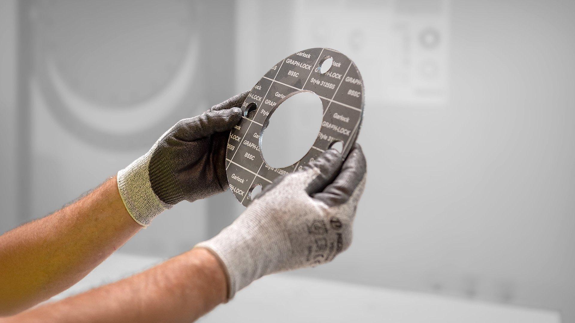 A man holding a pipe fitting gasket