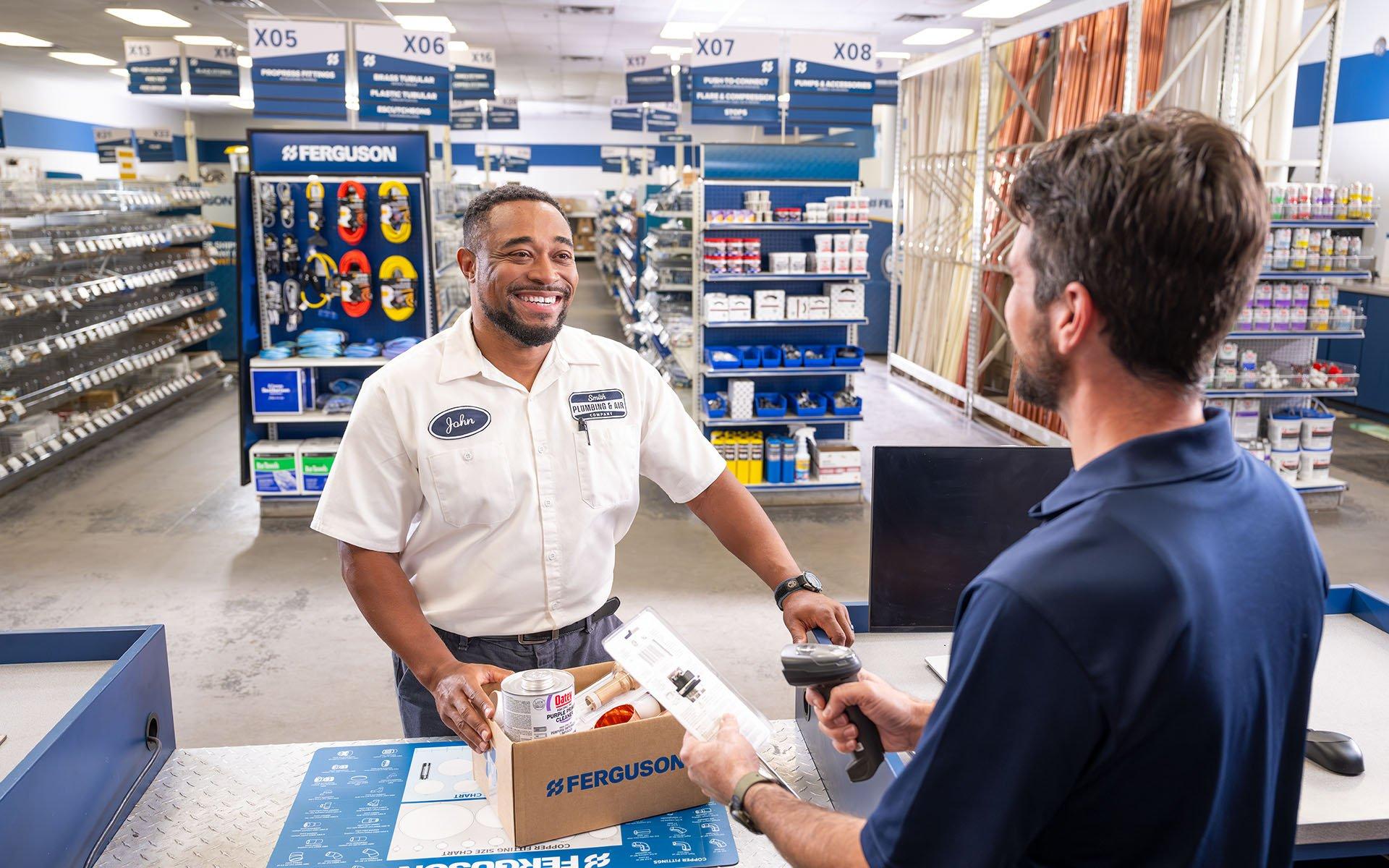 Plumber buys box of water heater parts in a Ferguson store