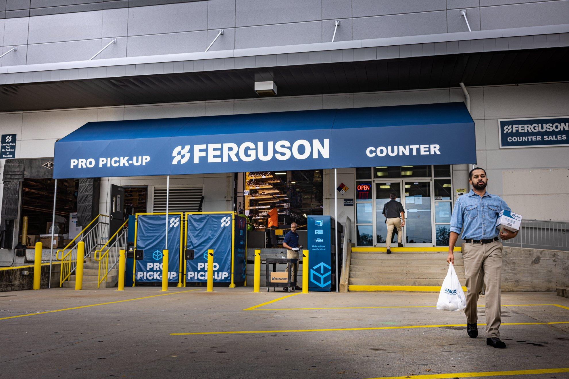 A customer carries bags out of a Ferguson Counter location.