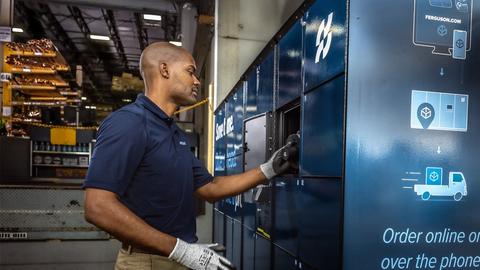 A gloved Ferguson associate places an order in a Pro Pick-Up locker.