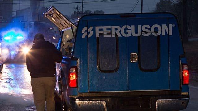 A man unloads items from a Ferguson emergency truck on a rainy night.