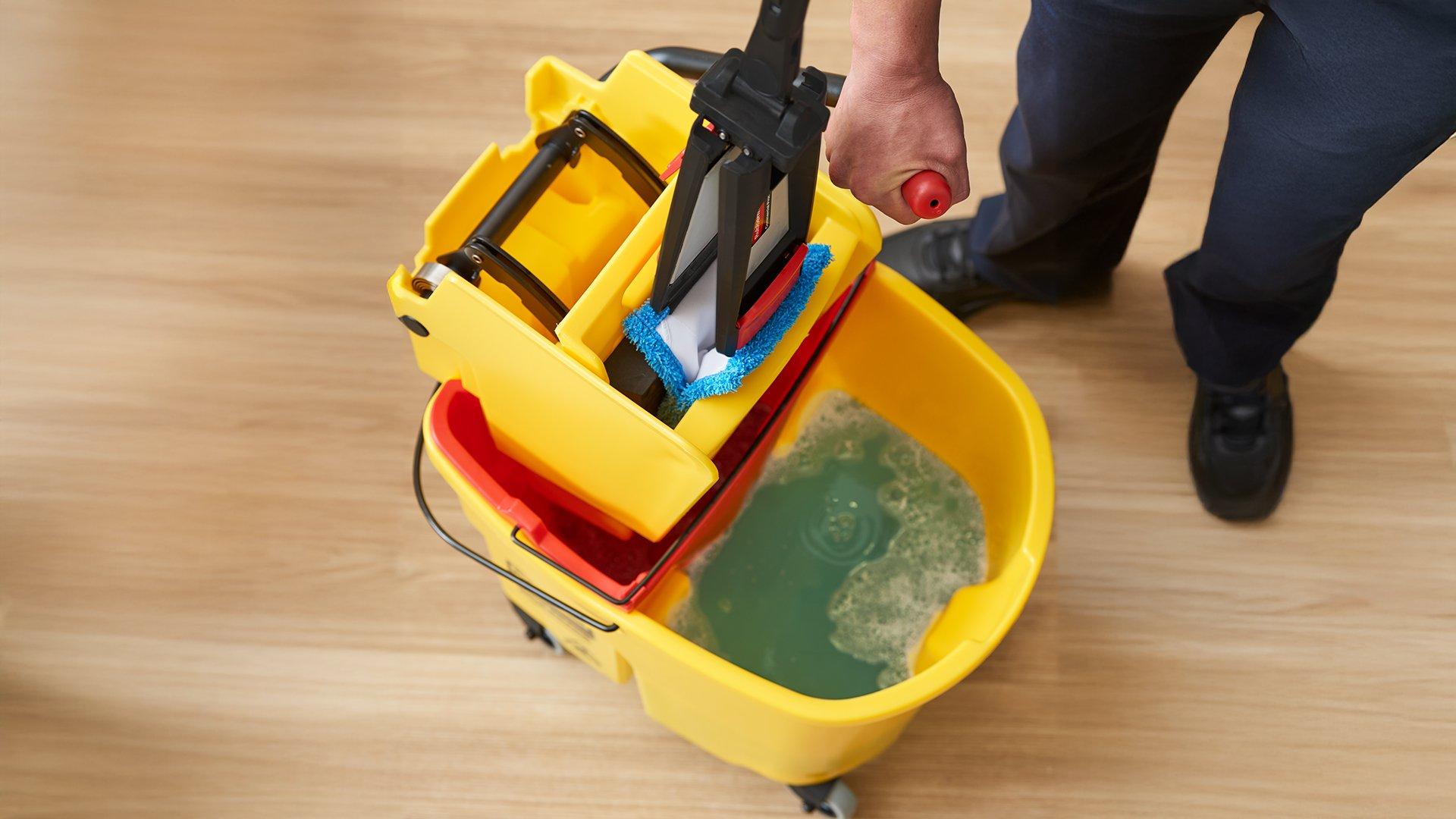 Rubermaid adaptive flat mop blue pad with wave brake in ringer close up.