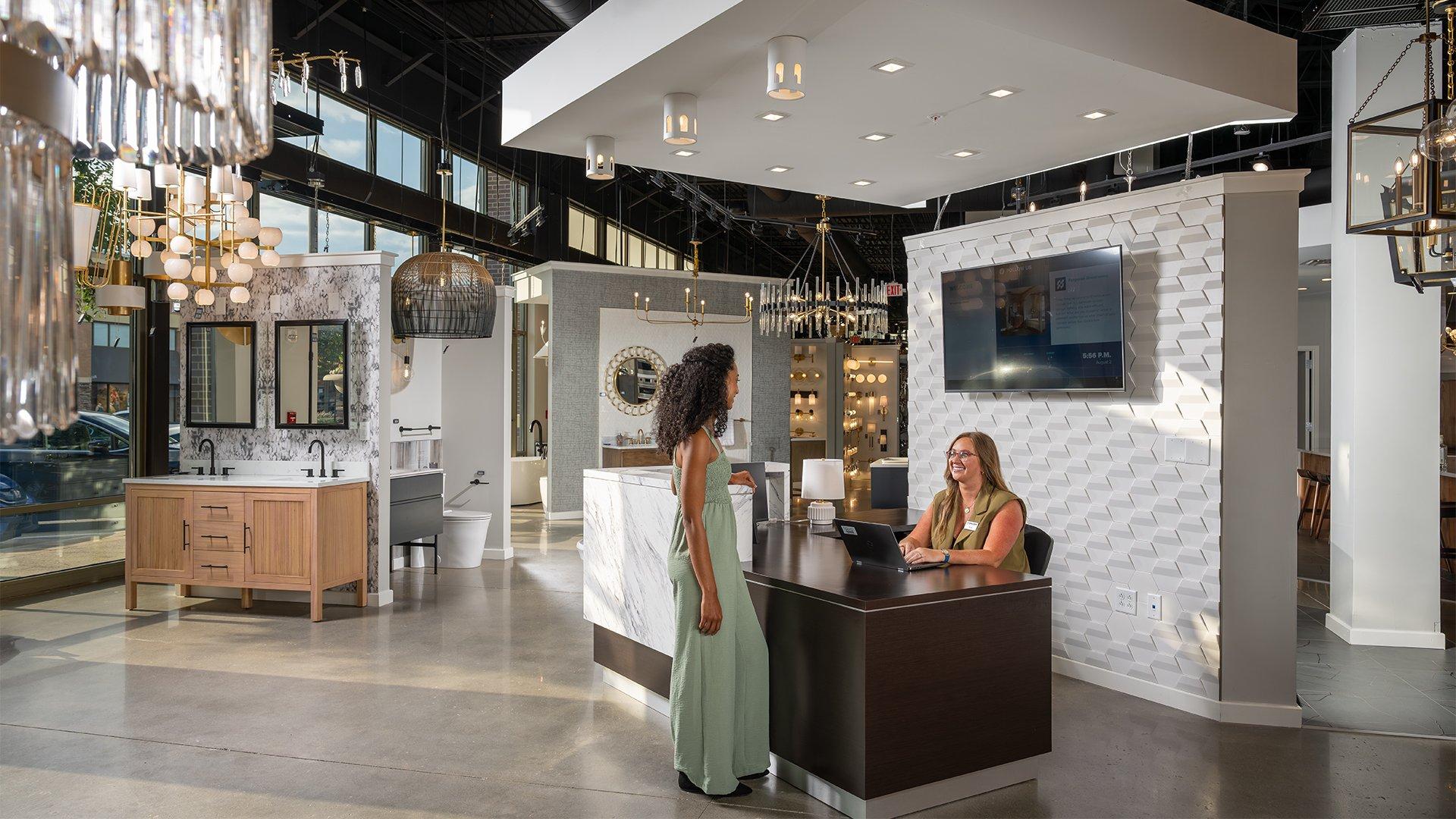 A Ferguson Home employee greets customer as she approaches the desk at a Ferguson Home showroom.