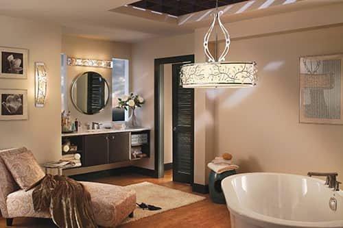 An earth-toned bathroom with a standalone bathtub, a vanity, a chaise lounge and wood flooring.