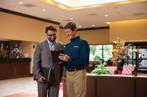 A Ferguson associate reviews a catalog with a man in a suit.