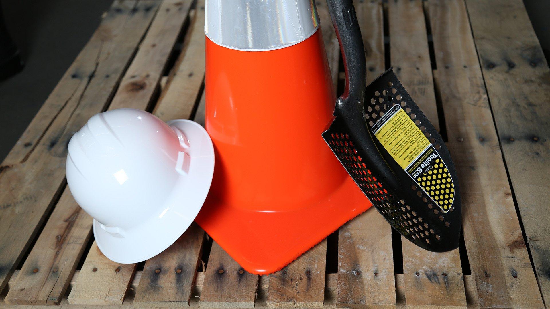 Silo image with a hardhat, traffic cone and shovel