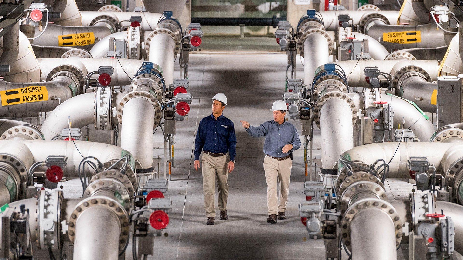 Two associates walk through waterworks facility. 