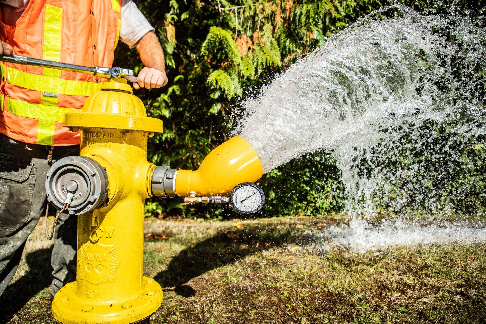 Water flows out of a yellow fire hydrant.