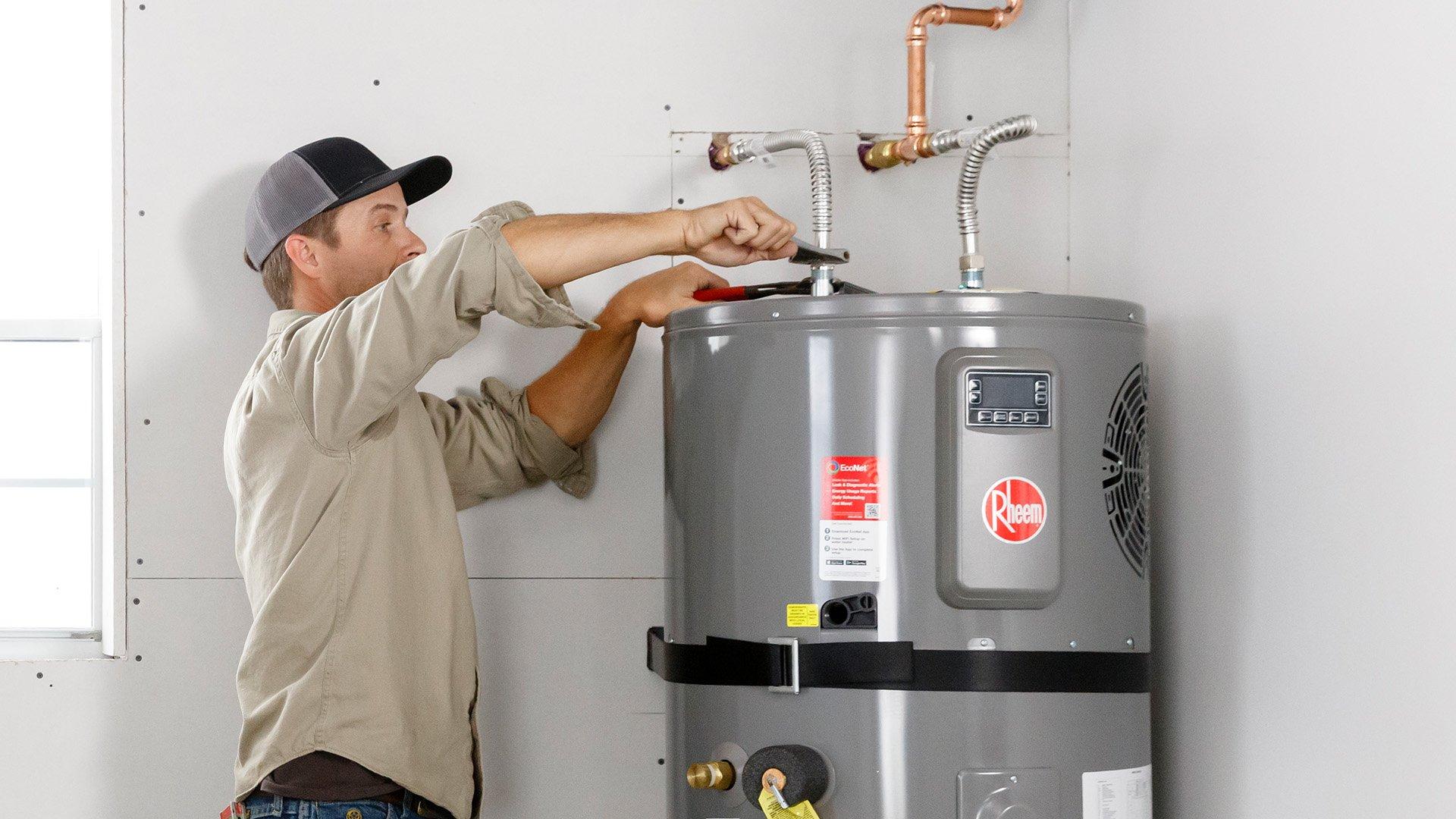 Plumber installs Rheem water heater in residential home. 