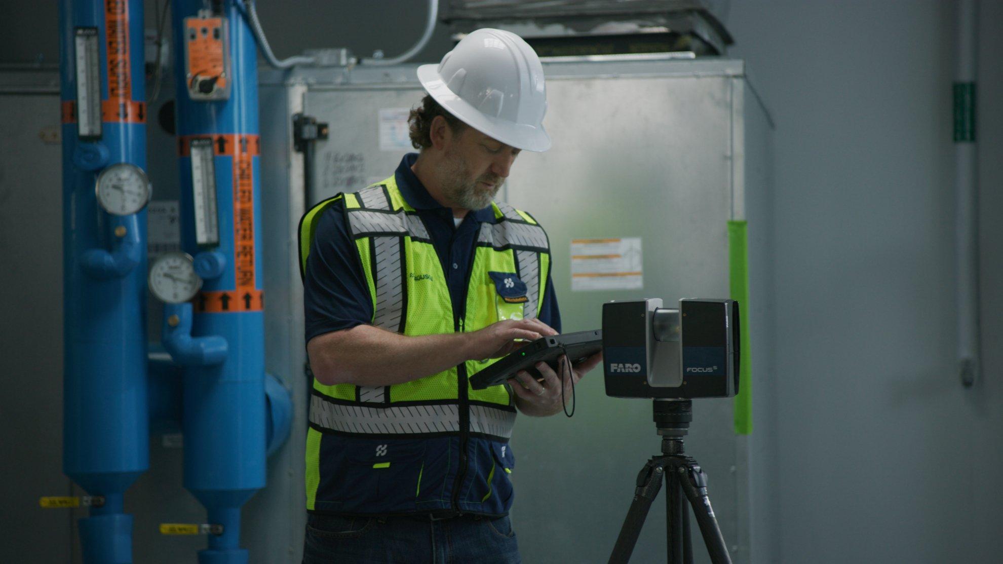A Ferguson associate prepares the Faro 3D scanner in an industrial building.