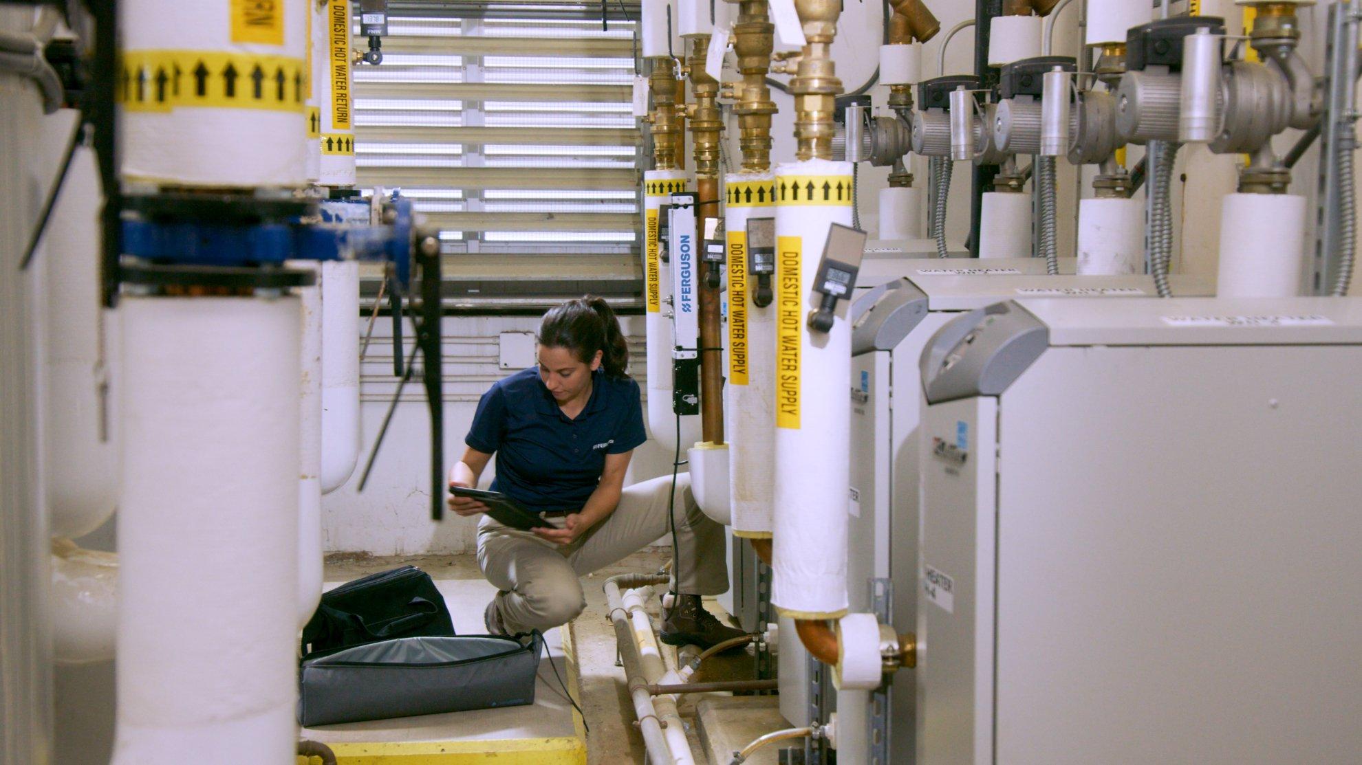 A Ferguson associate conducts a field audit on a building’s water system.