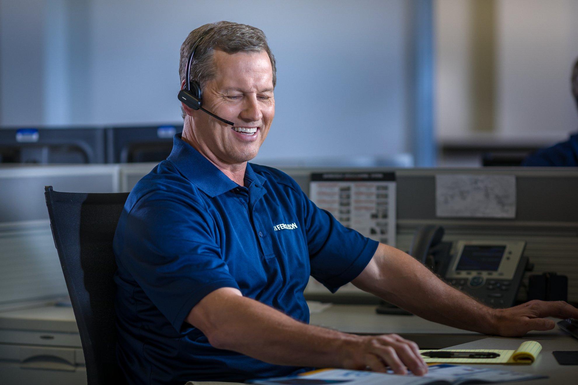 A Ferguson associate in a call center speaks into his headset.