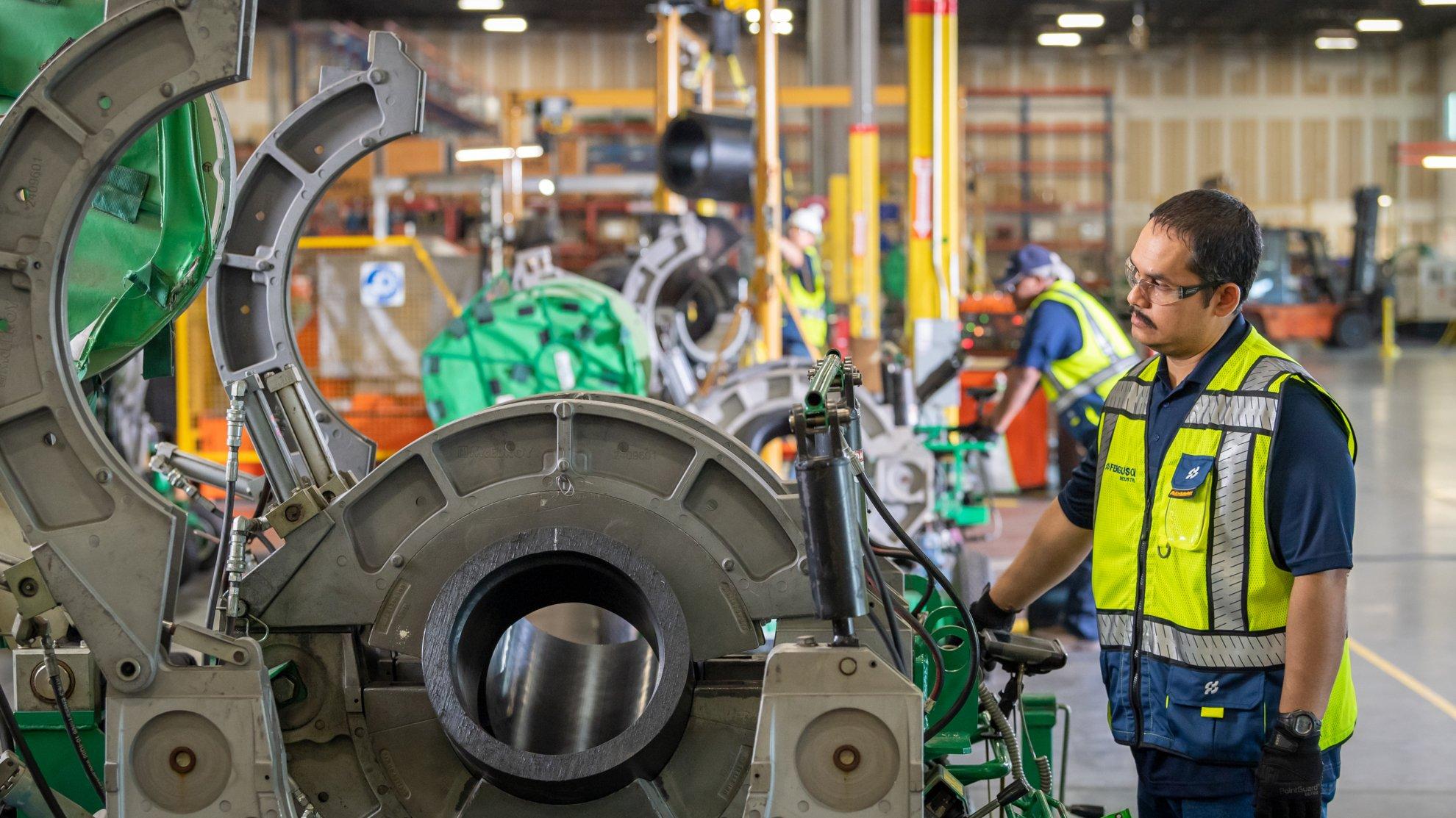 A Ferguson associate examines a pipe fusion machine.